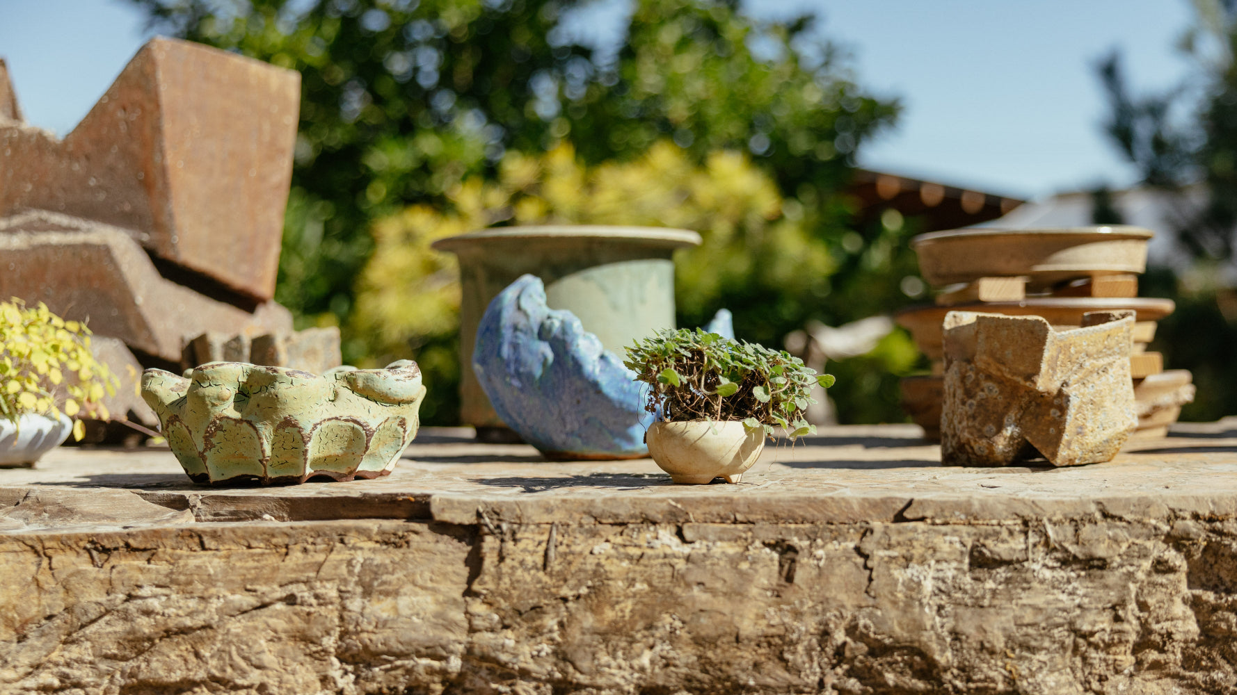 Decorative pots and stones on a rustic wooden surface with a blurred natural background